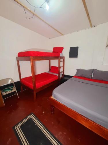 a bedroom with two beds and a red chair at Drifters@One Mile in Negril