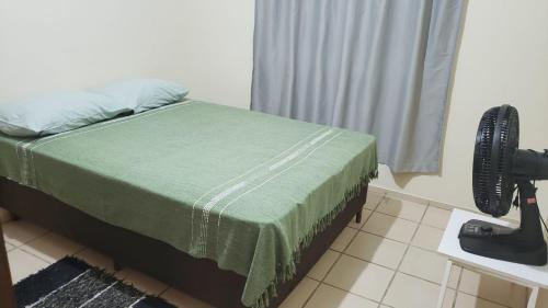 een slaapkamer met een bed met een groene deken bij Casa maravilhosa in Cabo Frio