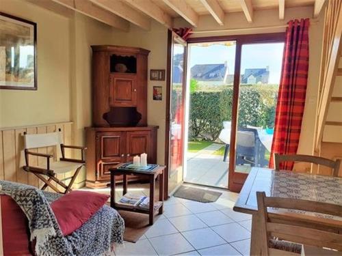 d'un salon avec une table et une porte coulissante en verre. dans l'établissement Charmante Maison avec Piscine, Tennis, Proche Mer - Idéal Famille - FR-1-392-140, à Batz-sur-Mer