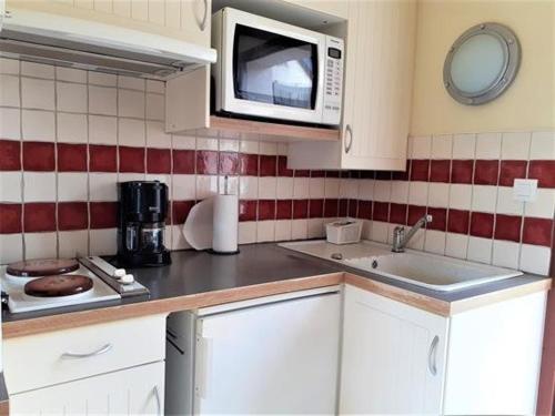eine Küche mit einer Spüle und einer Mikrowelle in der Unterkunft Appartement Batz-sur-Mer, 2 pièces, 4 personnes - FR-1-392-140 in Batz-sur-Mer