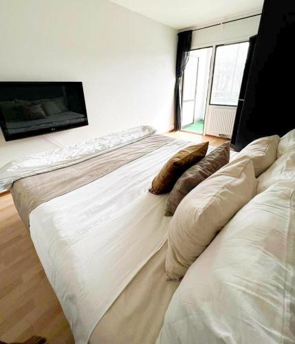 Una cama grande en una habitación con almohadas. en Private Room in Apartment en Malmö