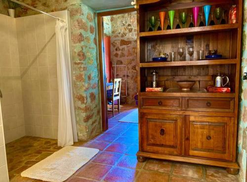 La salle de bains est pourvue d'un lavabo et d'une armoire en bois. dans l'établissement Villa & Poolhouse with Private Pool 360 degrees view 'Spinola' in pure nature, à Alozaina