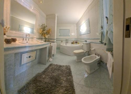 bagno con 2 lavandini, servizi igienici e vasca di Bellini Garden Suite a Catania