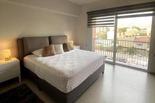 a bedroom with a large bed and a balcony at apartamento (de) Linda in Puerto Vallarta