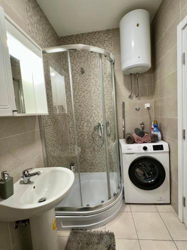 a bathroom with a shower and a washing machine at Apartman Lux Doboj 2 in Doboj