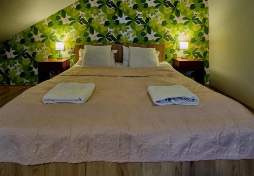 a bedroom with a large bed with two towels on it at Bohema Restauracja i Noclegi in Supraśl