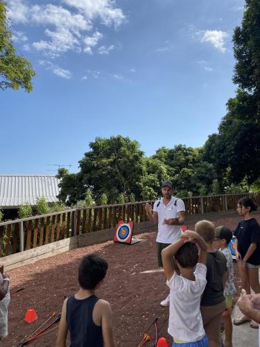 a woman flying a kite with a group of children at Les Aigrettes in Saint-Gilles les Bains