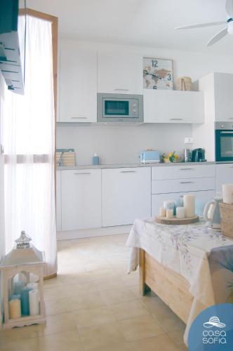 a kitchen with white cabinets and a table at CASA SOFIA in Scalea