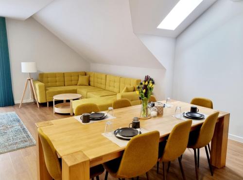 a dining room with a table and a couch at Aparthotel Bukowa in Tychy