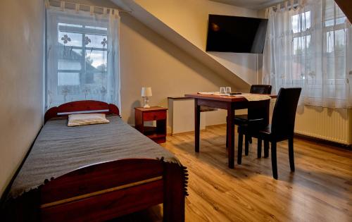 a bedroom with a bed and a desk and a table at Bohema Restauracja i Noclegi in Supraśl