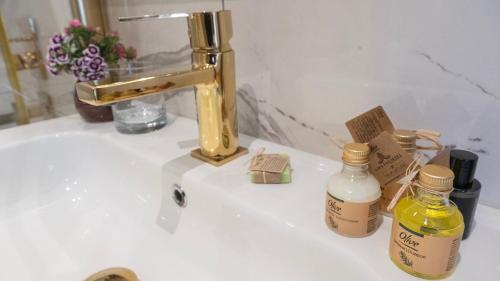 a bathroom sink with two bottles of soap and a gold faucet at Loop Hotel Bosphorus İstanbul in Istanbul