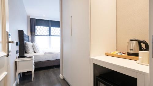 a room with a bed and a kitchen with a table at Loop Hotel Bosphorus İstanbul in Istanbul