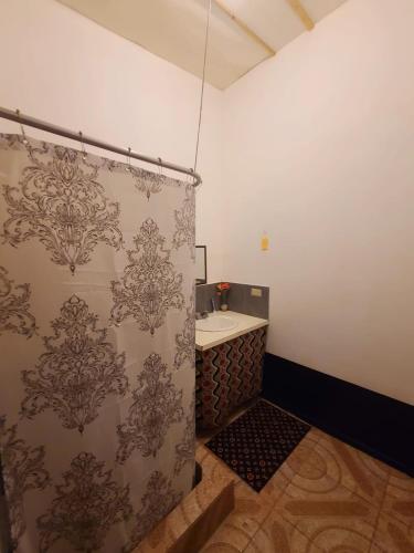 a bathroom with a shower curtain and a sink at Drifters@One Mile in Negril
