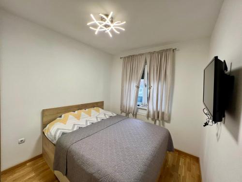 a bedroom with a bed and a television in it at Apartman Lux Doboj 2 in Doboj