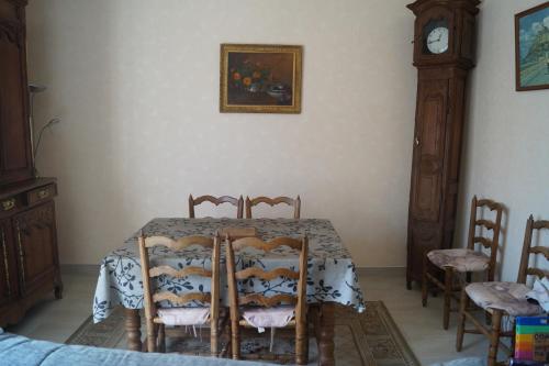une salle à manger avec une table et une horloge grand-père dans l'établissement Gîte de la Grève, à Beauvoir