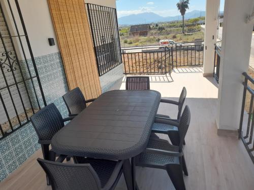 un tavolo nero e sedie sul balcone di Apartamentos playa de bellreguard,gandia,oliva,denia,benidorm a Bellreguart