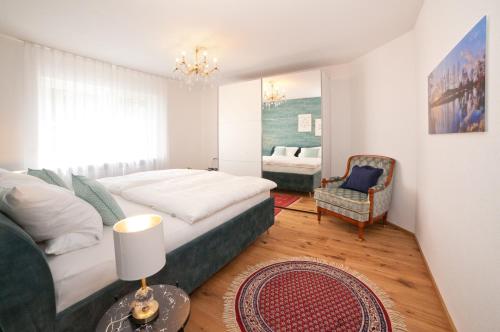 um quarto com uma cama grande e uma cadeira em Tauberperle - Exklusives Ferienapartment em Lauda-Königshofen