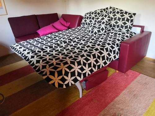 uma cama preta e branca num quarto com um sofá em Appartement Schelhas em Prien am Chiemsee