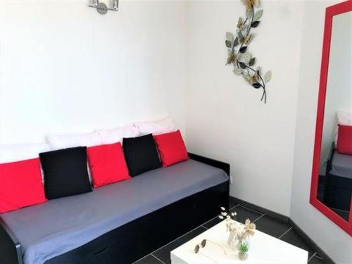 Cette chambre comprend un lit avec des oreillers rouges et noirs. dans l'établissement Studio agréable à Pornichet, proche plage et commerces - FR-1-392-150, à Pornichet