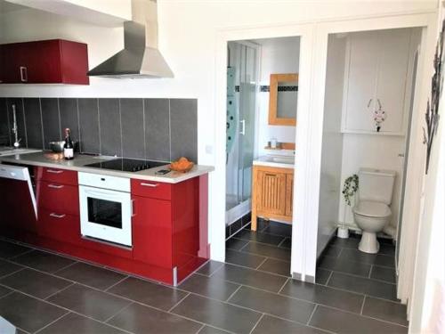 une cuisine avec des placards rouges et des toilettes. dans l'établissement Studio agréable à Pornichet, proche plage et commerces - FR-1-392-150, à Pornichet