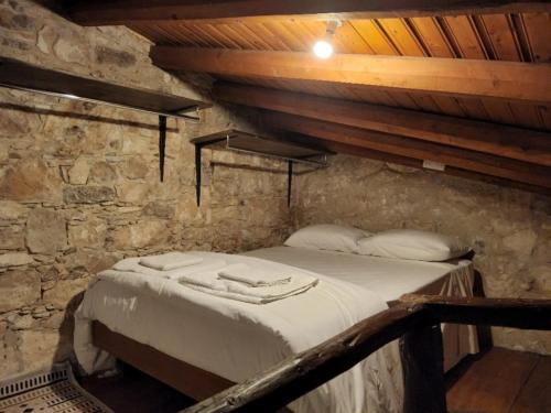 1 dormitorio con 1 cama en una pared de piedra en Galileo Cottage House (BREAKBOOKING CY), en Parekklisha
