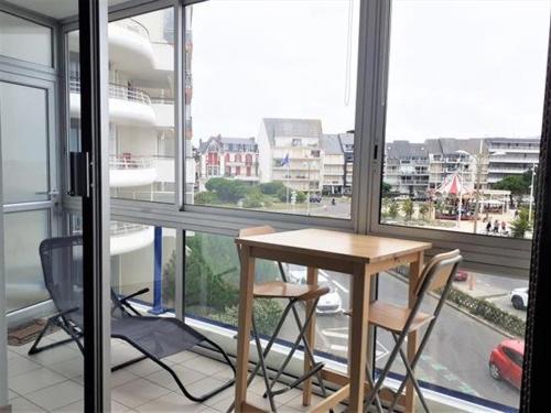 une table et des chaises dans une pièce avec des fenêtres dans l'établissement Studio agréable à Pornichet, proche plage et commerces - FR-1-392-150, à Pornichet