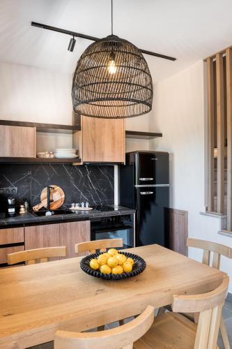 a kitchen with a wooden table with a bowl of fruit on it at Sezian Boutique Homes and Villas in Preveza