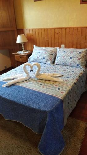 two swans shaped towels are on a bed at Casa pedrolo in Outes