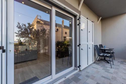 a balcony with sliding glass doors and a table at Quiet comfortable apartment Quo Vadis in Kaštela