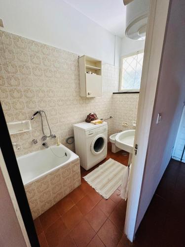 a bathroom with a tub and a washing machine at Appartamento Pastenau in Piazza