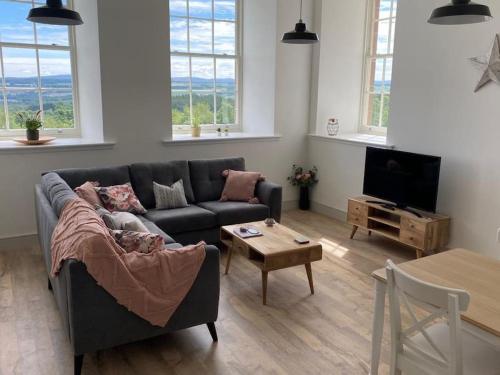 a living room with a couch and a table at Premium apartment in a peaceful location with great views. in Inverness