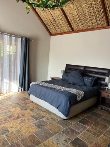 een slaapkamer met een bed en een houten plafond bij JUMANJI NATURE RESORT in Hartbeespoort