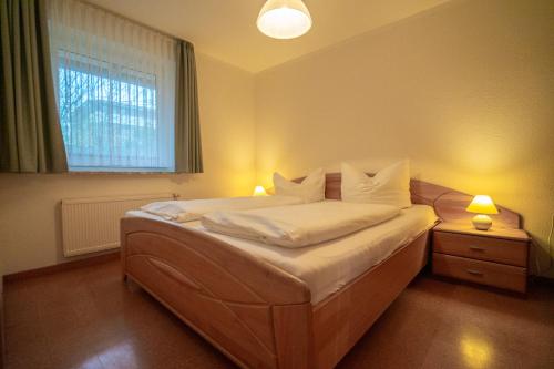 a bedroom with a bed with white sheets and a window at Felber in Büsum