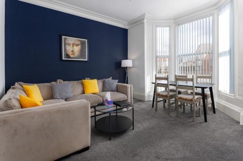 un soggiorno con divano e tavolo di Flatzy - Huge 7 Bed House Close to Football Stadiums a Liverpool