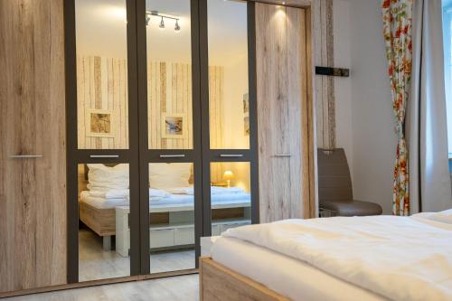 a bedroom with a mirrored closet with a bed in it at Hohenzollernpassage Wohnung Seemöwe in Büsum