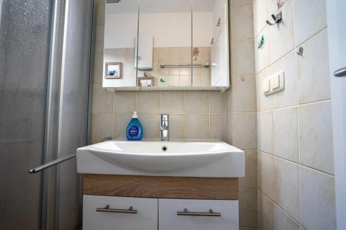 a bathroom with a white sink and a shower at Hohenzollernpassage Wohnung Seemöwe in Büsum