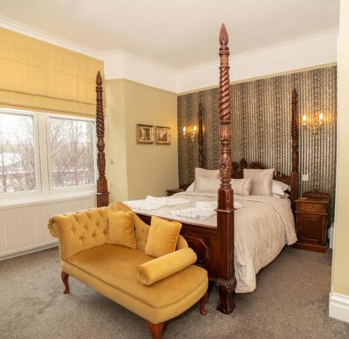 a bedroom with a large bed and a chair at Beaumont Guest House - FREE off-site Health Club - Adults Only in Windermere