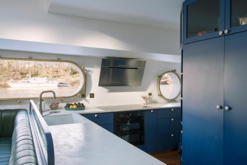a kitchen with blue cabinets and a sink at Escale Sur Seine in Paris