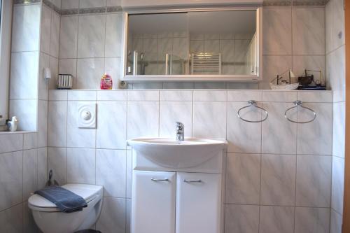 uma casa de banho branca com um lavatório e um WC em Achtern Hafen em Büsum