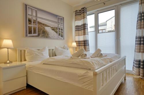 Un dormitorio con una cama blanca con dos bebés. en Meeresrauschen, en Büsum