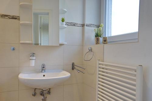 uma casa de banho com um lavatório e um espelho em Deichstern em Büsum