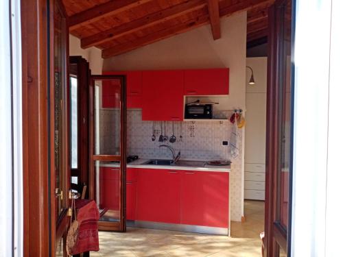 una cocina con armarios rojos y fregadero en Agrisport Cà di Cuni en Roncagli
