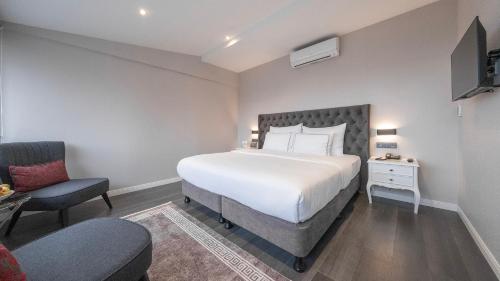 a bedroom with a large white bed and a chair at Loop Hotel Bosphorus İstanbul in Istanbul