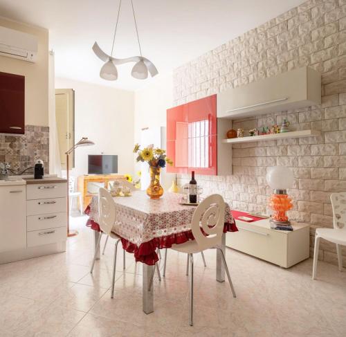 a kitchen with a table with chairs and red cabinets at A casa tua Affitti brevi in Noto