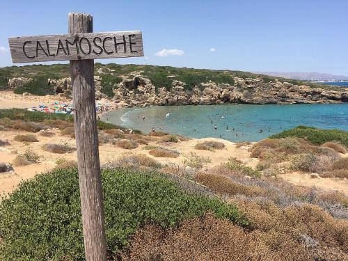 a sign on a beach with people in the water at A casa tua Affitti brevi in Noto