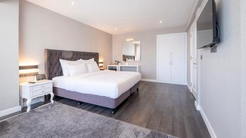 a bedroom with a large white bed and a television at Loop Hotel Bosphorus İstanbul in Istanbul