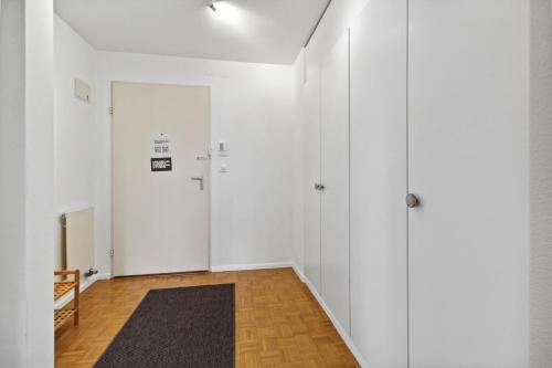 an empty hallway with white walls and a door at Beautiful Boutique Apartment DRAHTZUG8 in Zürich