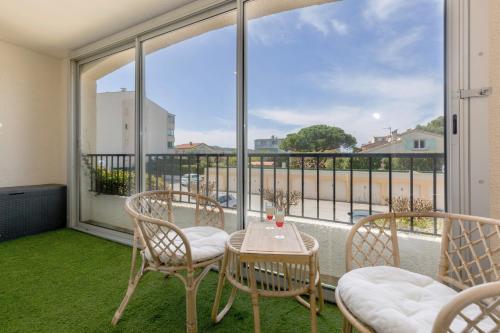 un balcon avec une table et des chaises et une grande fenêtre dans l'établissement The Serengeti - Cosy - Plage - Host Provence, à La Seyne-sur-Mer