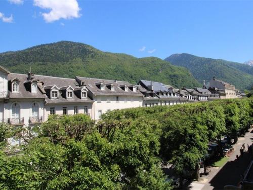 une rangée de bâtiments sur une colline avec une rivière dans l'établissement Studio Central 2 Pers, Parking, Proche Thermes & Commerces - FR-1-313-156, à Luchon