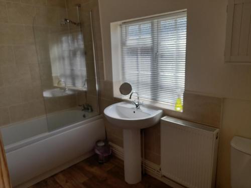 a bathroom with a sink and a bath tub and a sink at The Little House Louth in Louth